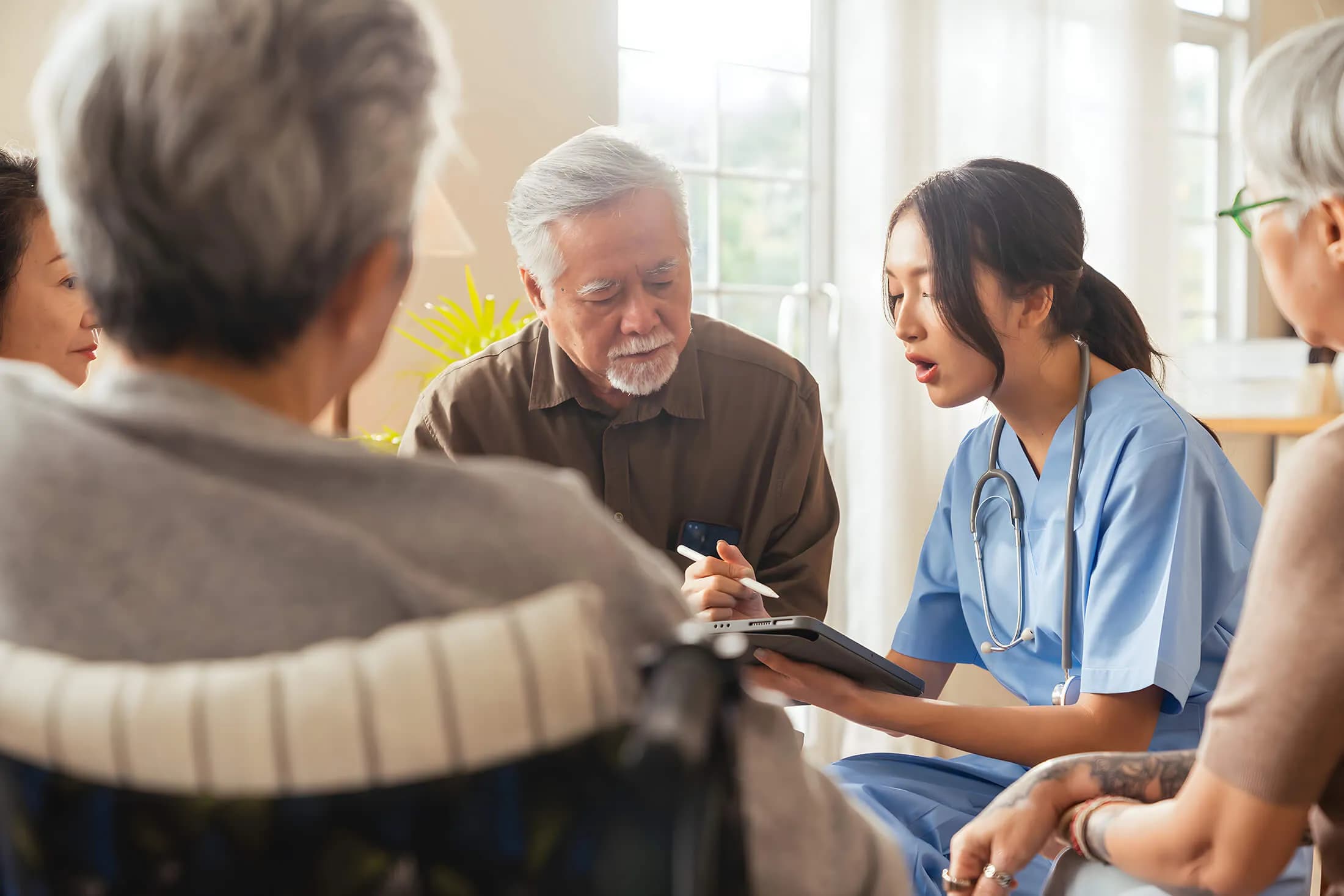Female nurse explaining medical charts to group of people.